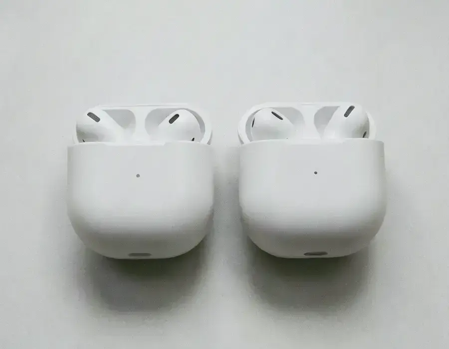 Two compact wireless earbud cases side by side on a pale surface