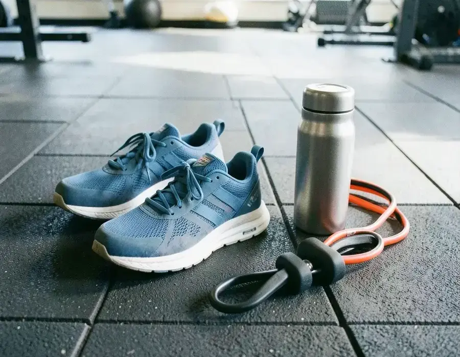 Running shoes and training kit arranged on a rubber floor